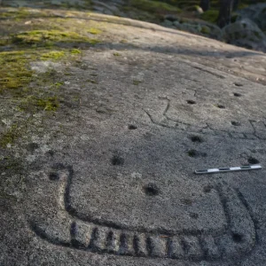 Hällristning med skeppsmotiv från bronsåldern på berghäll i svensk skog